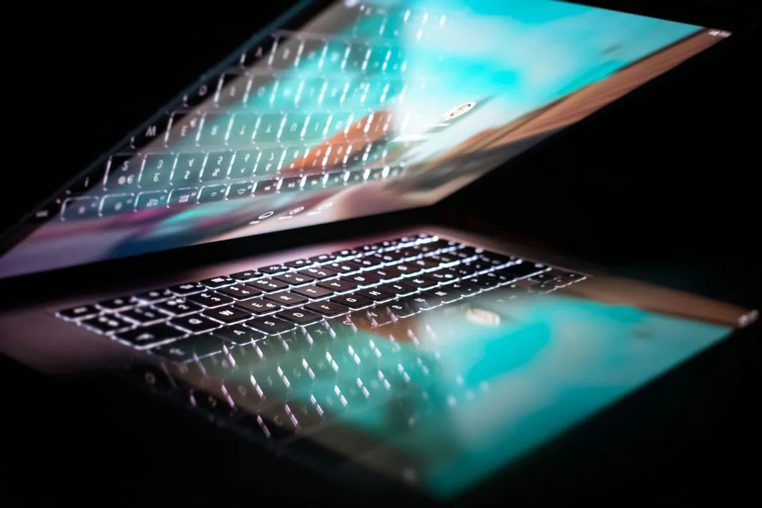 Microsoft 365 Weekly Change Intelligence | 24th-30th August 2026 5 Modern laptop with illuminated keyboard and screen reflection on a dark background.